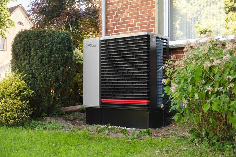 Luft-Wasser-Wärmepumpe im Garten eines Wohnhauses